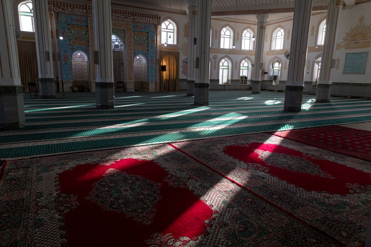 Saf karpet masjid bergaris hijau dan merah yang rapi untuk pelaksanaan shalat berjamaah