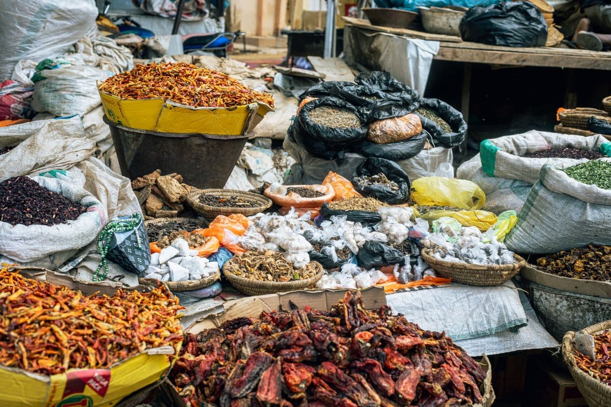 Berbagai macam rempah-rempah dan buah kering yang dijual dalam wadah karung di pasar tradisional.